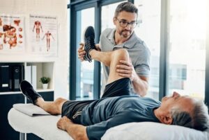 Vardan specialist supporting hip and knee mobility for elderly patient through targeted functional manual therapy.