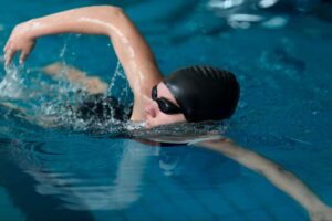 Swimmer gliding through water, protecting shoulders and back