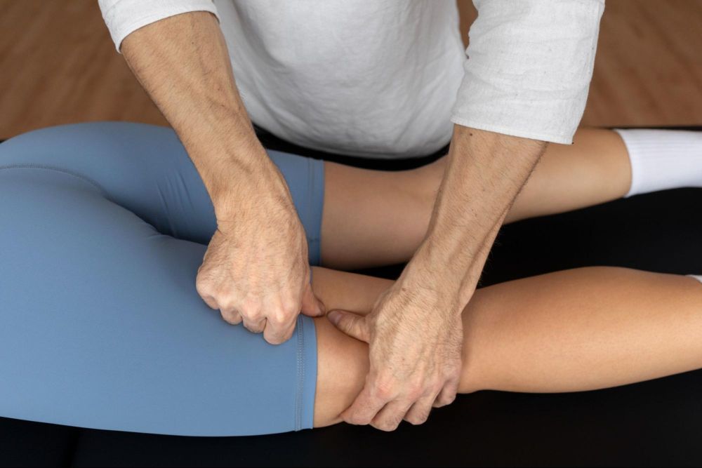 VARDĀN ( Physiotherapy Centre, New Delhi) Therapist Performing Functional Manual Therapy (FMT) on a patient’s thigh to release soft-tissue restrictions, improve hamstring flexibility, and restore lower-limb mobility