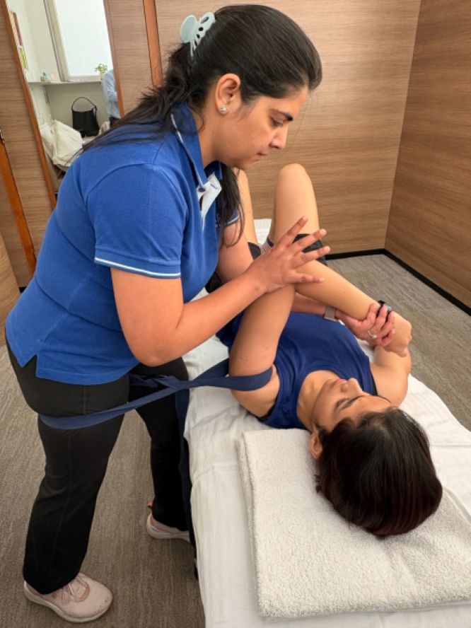Functional manual therapist at VARDĀN performing hands-on shoulder and upper limb assessment during a functional manual therapy session