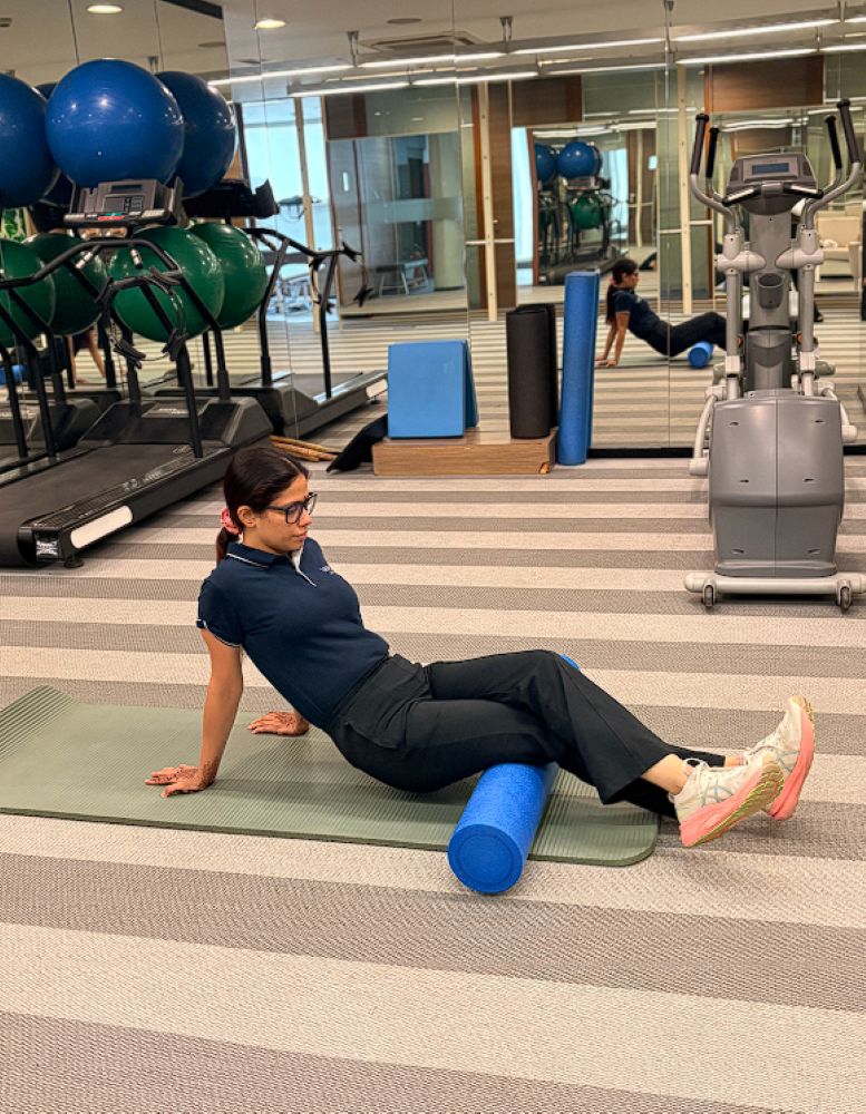 Woman performing foam rolling exercise on legs in VARDĀN advanced physiotherapy centre.