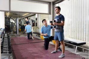 VARDĀN trainer assisting a man with exercises with strength training equipment