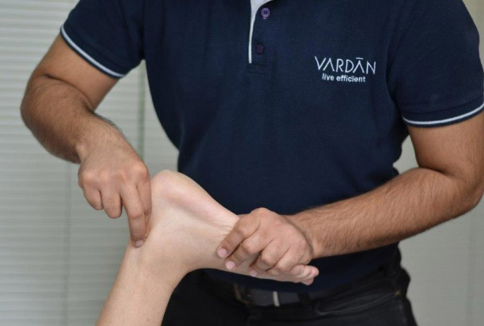 Physiotherapist performing knee assessment at VARDĀN Delhi
